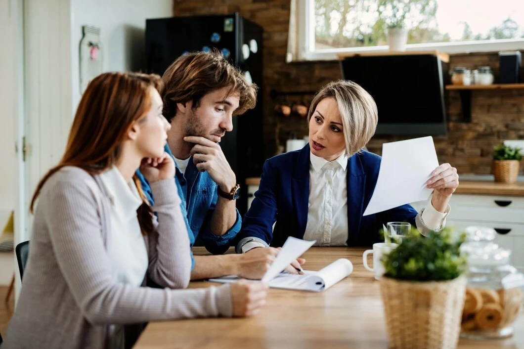 Agent explaining property documents to couple